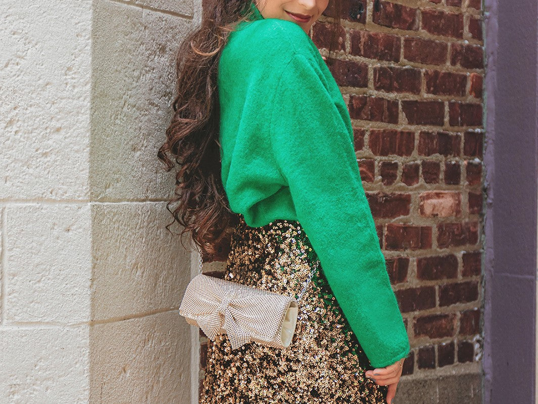 Jessica is in a green sweater with a shiny skirt on as she shows off her Hailey Bow Clutch Wallet. Jessica McClintock offers evening bags, clutches, wristlets, pouches, brooch, minaudiere, and hobo clutches for formal and semi formal events and dinners.  
